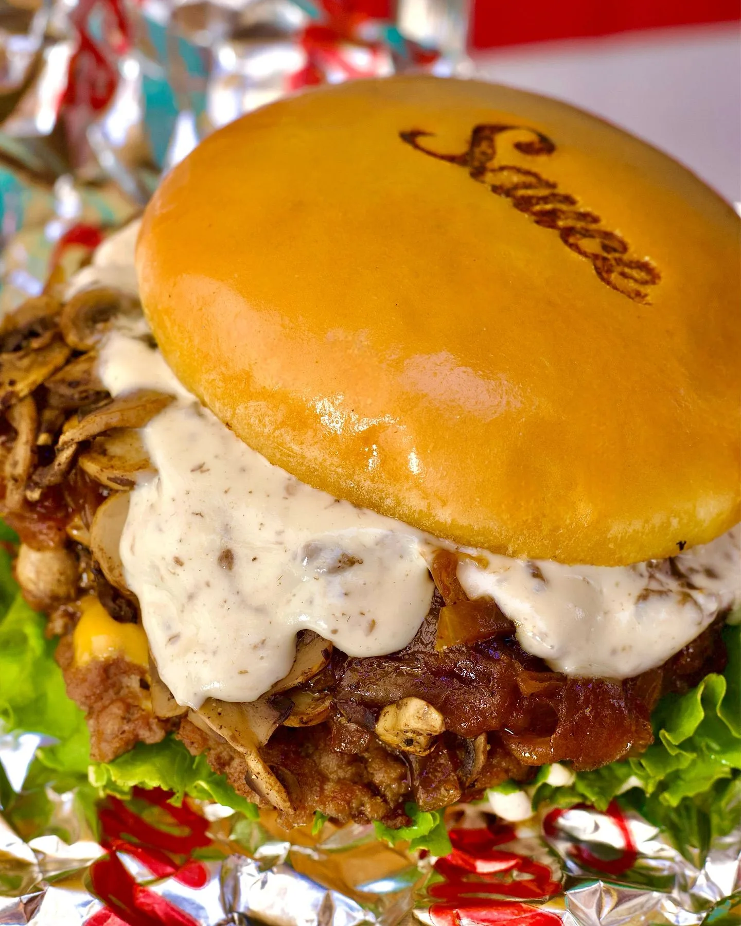 Close-up of a Sauce burger dripping with truffle mayo