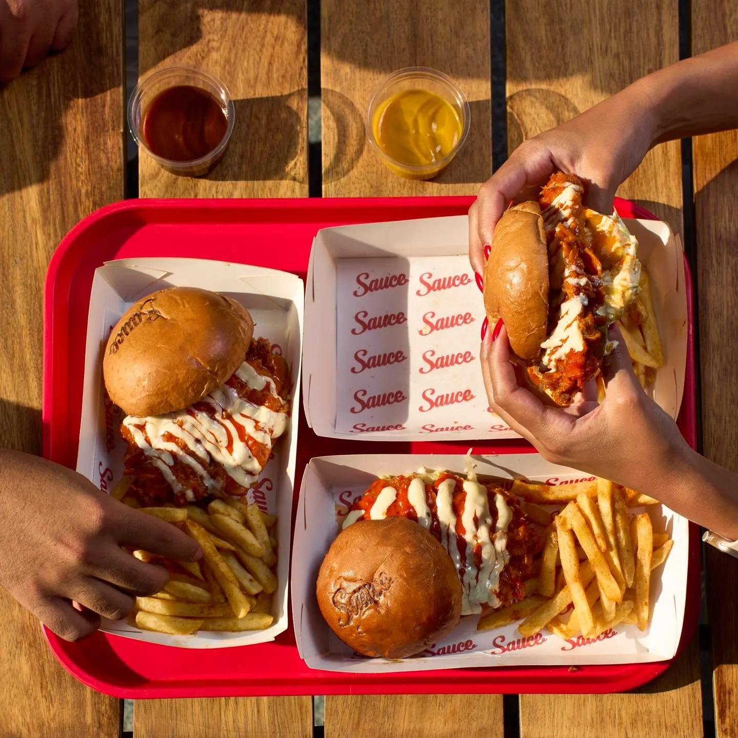 A Sauce tray with burgers, fries and dips